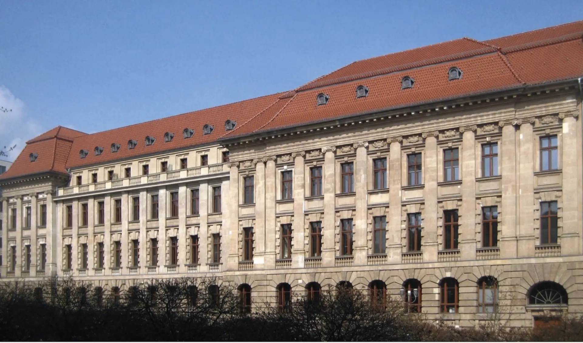 Neoclassical stone banking house facade with a red tiled roof at Berlin's Gendarmenmarkt